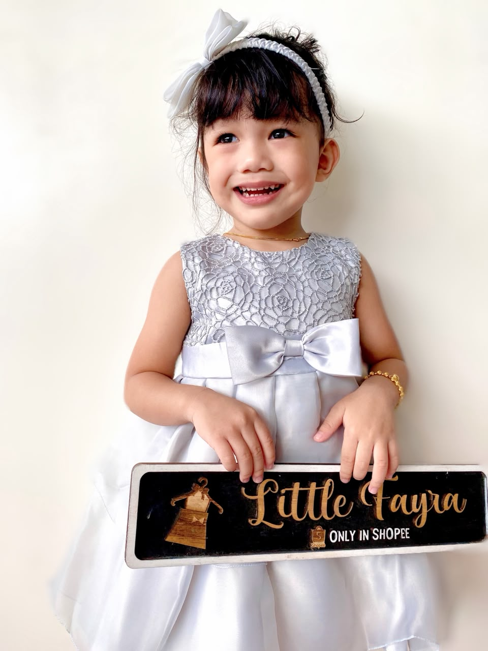Aisyah wearing a white Little Fayra dress